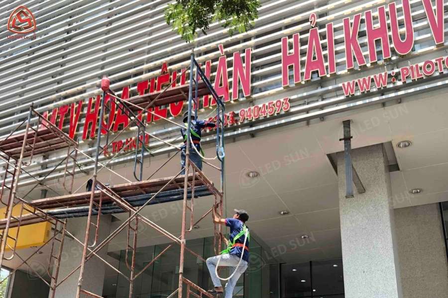 Đội thi công lắp bảng hiệu chữ nổi mặt tiền cửa hàng bằng giàn giáo
